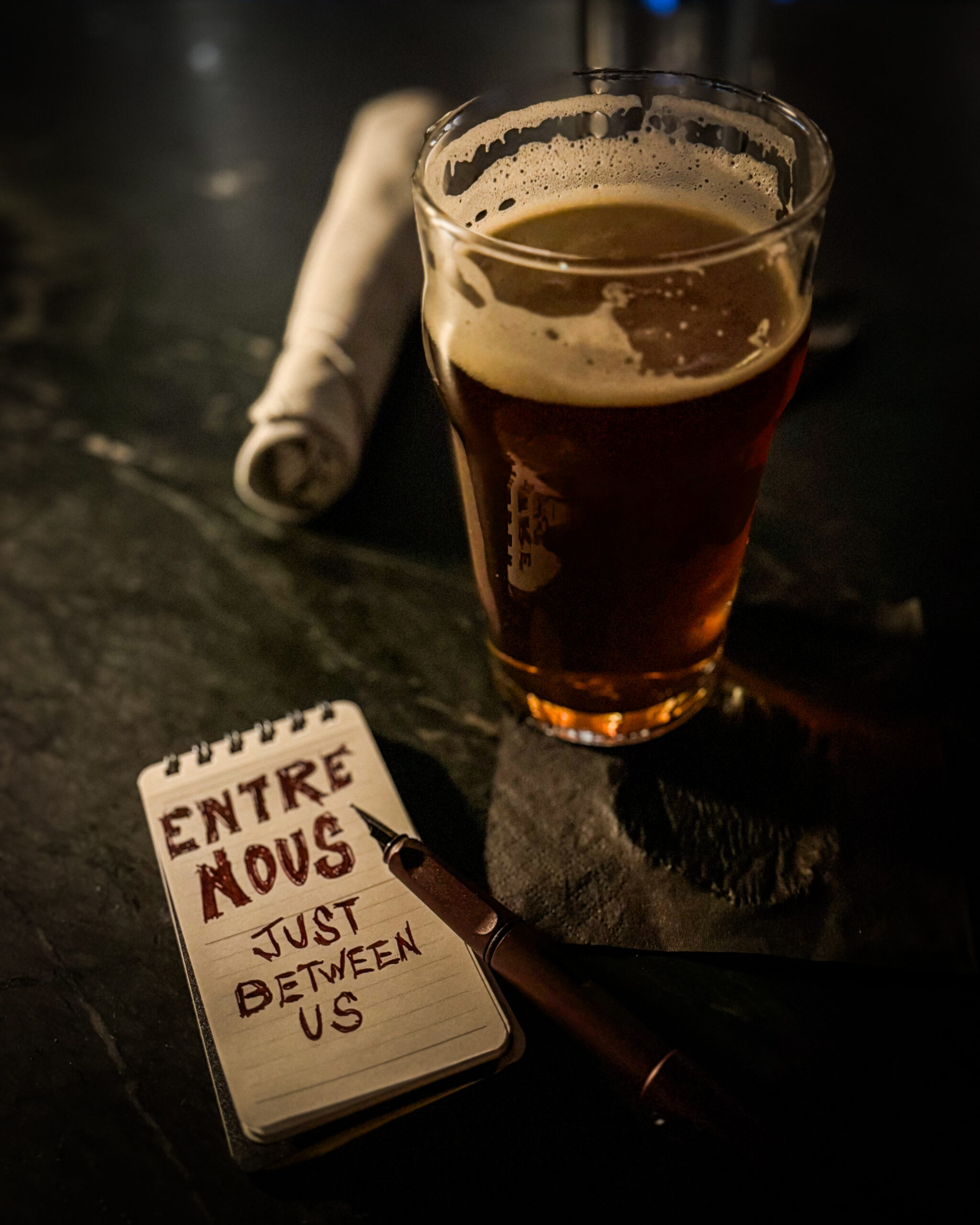 Entre Nous beer, fountain pen and notepad